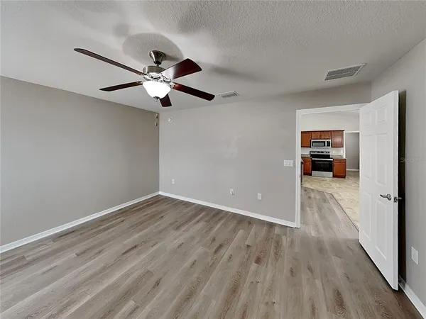 a view of empty room with wooden floor