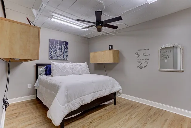 a bedroom with a bed and wooden floor