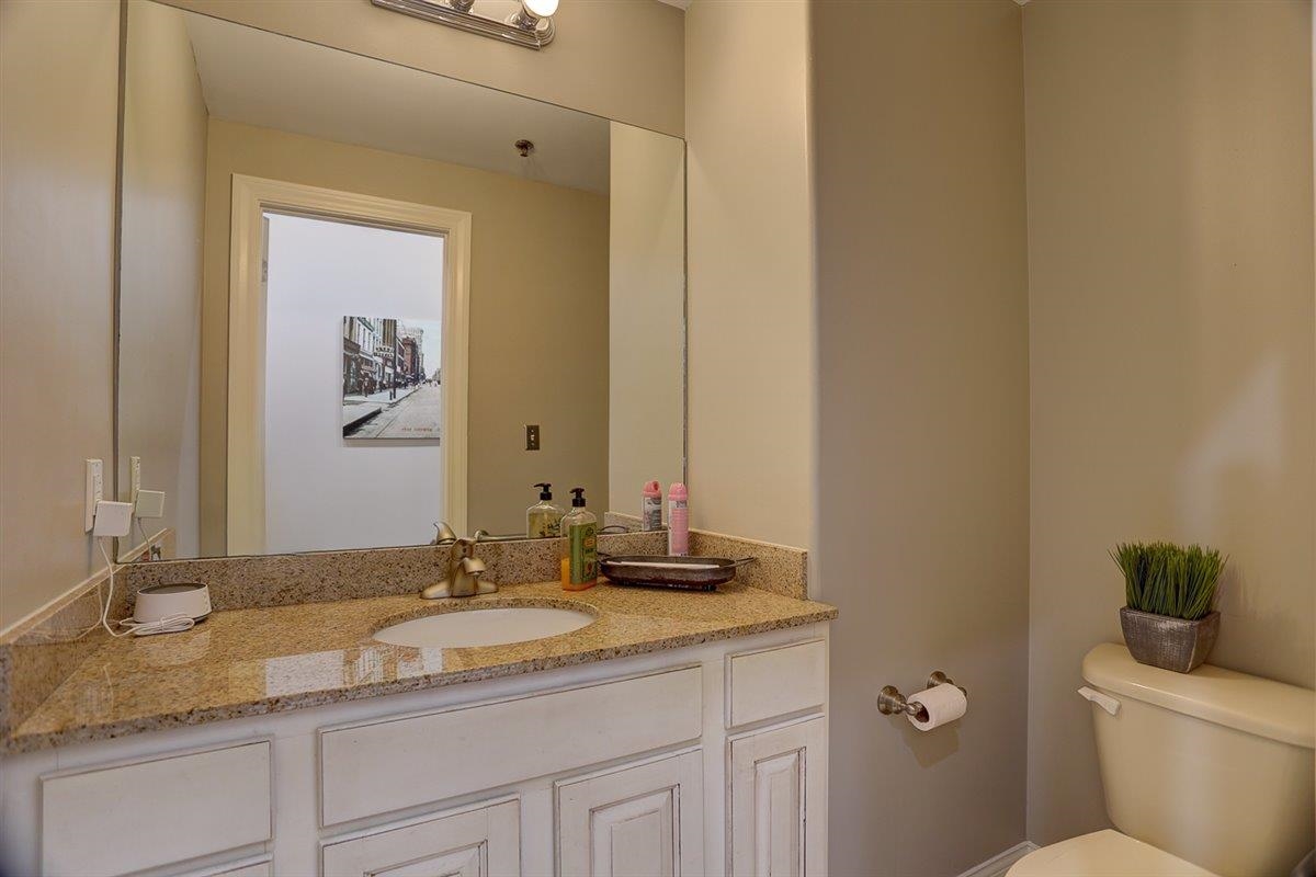 95 South Main Street, Unit 102 Memphis, TN 38103 - Photo 29 of 35 a bathroom with a granite countertop sink a toilet and a mirror