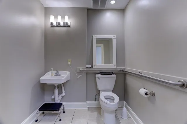 a bathroom with a toilet a sink and mirror