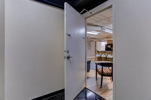 a view of a hallway with wooden floor and a bathroom