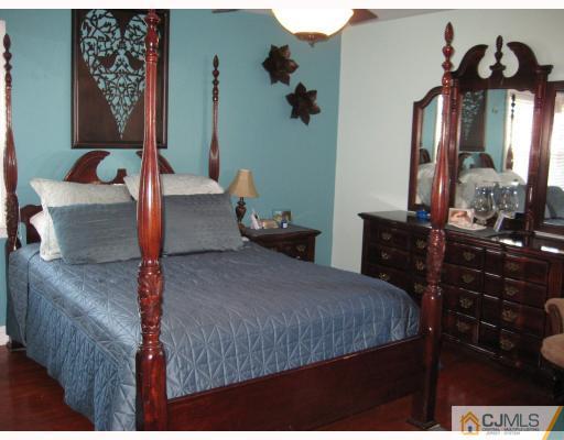 1 Birch Road Edison, NJ 08817 - Photo 5 of 10 a bedroom with a bed and dresser with mirror
