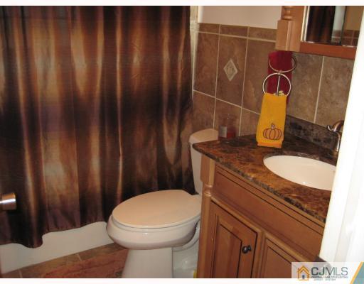 1 Birch Road Edison, NJ 08817 - Photo 8 of 10 a bathroom with a granite countertop toilet and sink