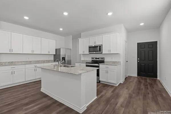 a kitchen with sink a microwave and cabinets