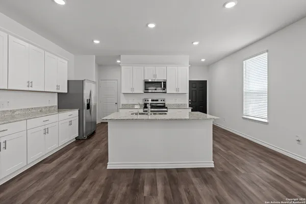 a kitchen with stainless steel appliances granite countertop a stove a sink and a refrigerator