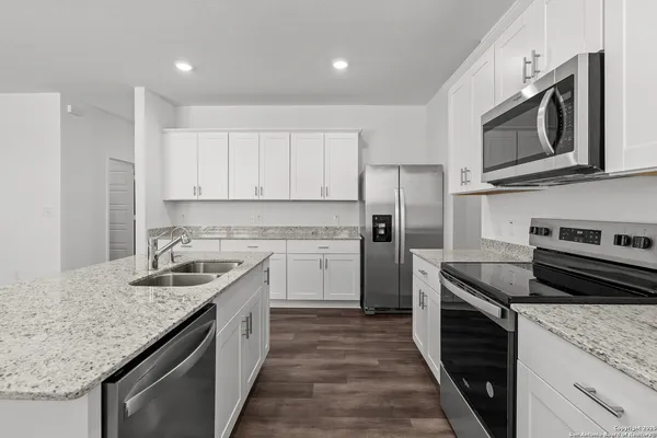 a kitchen with stainless steel appliances granite countertop a sink stove microwave and refrigerator