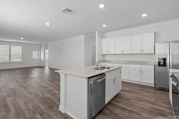 a kitchen with granite countertop white cabinets and white appliances
