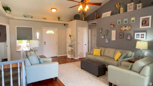 1797 Sunset Road Enoch, UT 84721 - Photo 19 of 80 Open-concept living space featuring wood-finish flooring, a vaulted ceiling with a ceiling fan, and a light-filled entryway with a decorative front door
