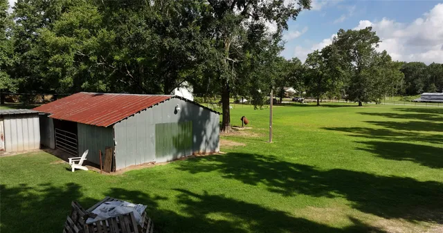an aerial view of residential houses with outdoor space and trees all around