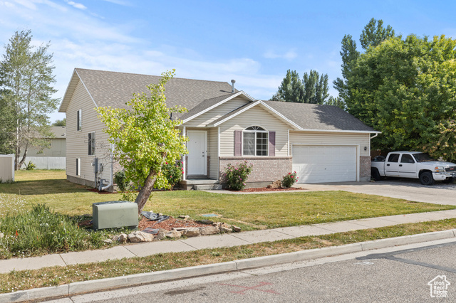 1099 Three Point Avenue Logan, UT 84321 - Photo 24 of 27 View of front facade featuring a garage, driveway, brick siding, and a shingled roof