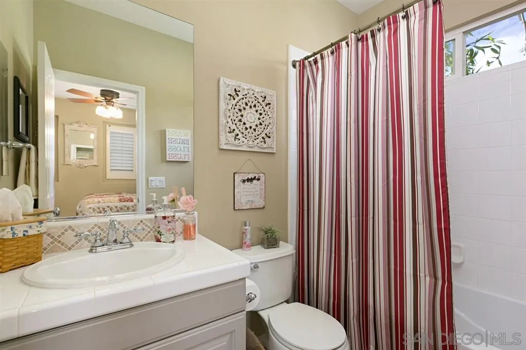 6991 Goldstone Road Carlsbad, CA 92009 - Photo 14 of 25 a bathroom with a sink a toilet and shower curtain
