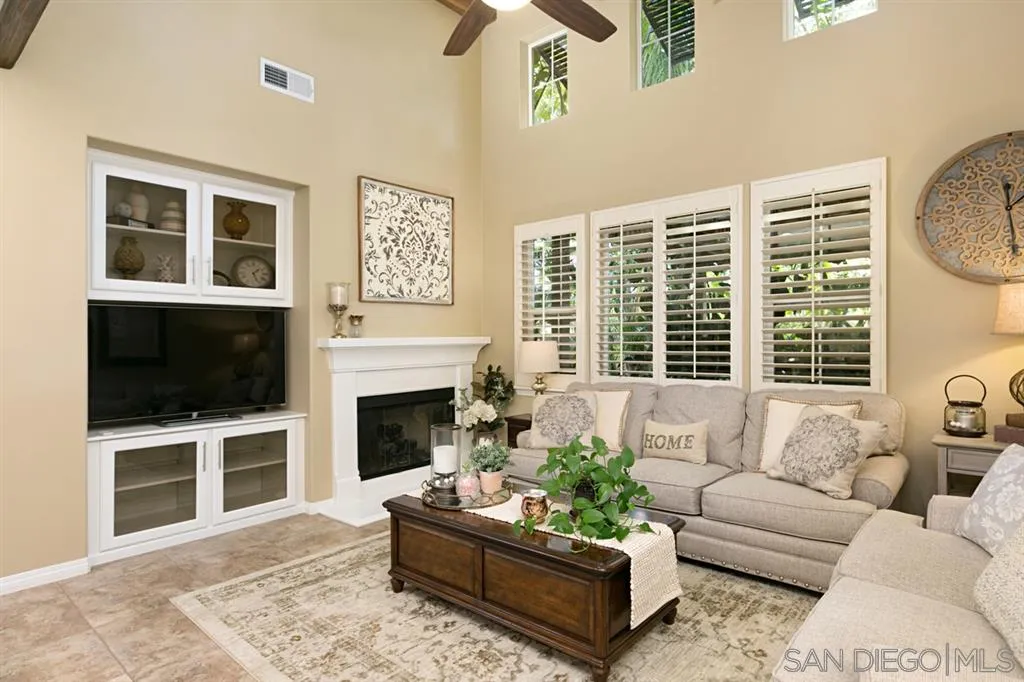 6991 Goldstone Road Carlsbad, CA 92009 - Photo 7 of 25 a living room with furniture a fireplace and a flat screen tv