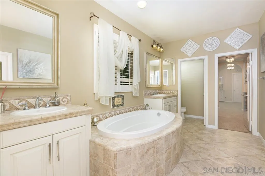 6991 Goldstone Road Carlsbad, CA 92009 - Photo 9 of 25 a bathroom with a sink double vanity granite tub and a mirror