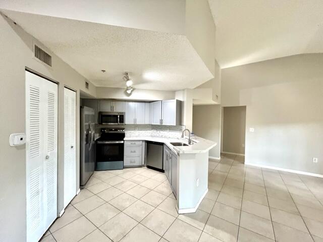 741 North Pine Island Road, Unit 303 Plantation, FL 33324 - Photo 6 of 32 a kitchen with a sink a counter top space and stainless steel appliances