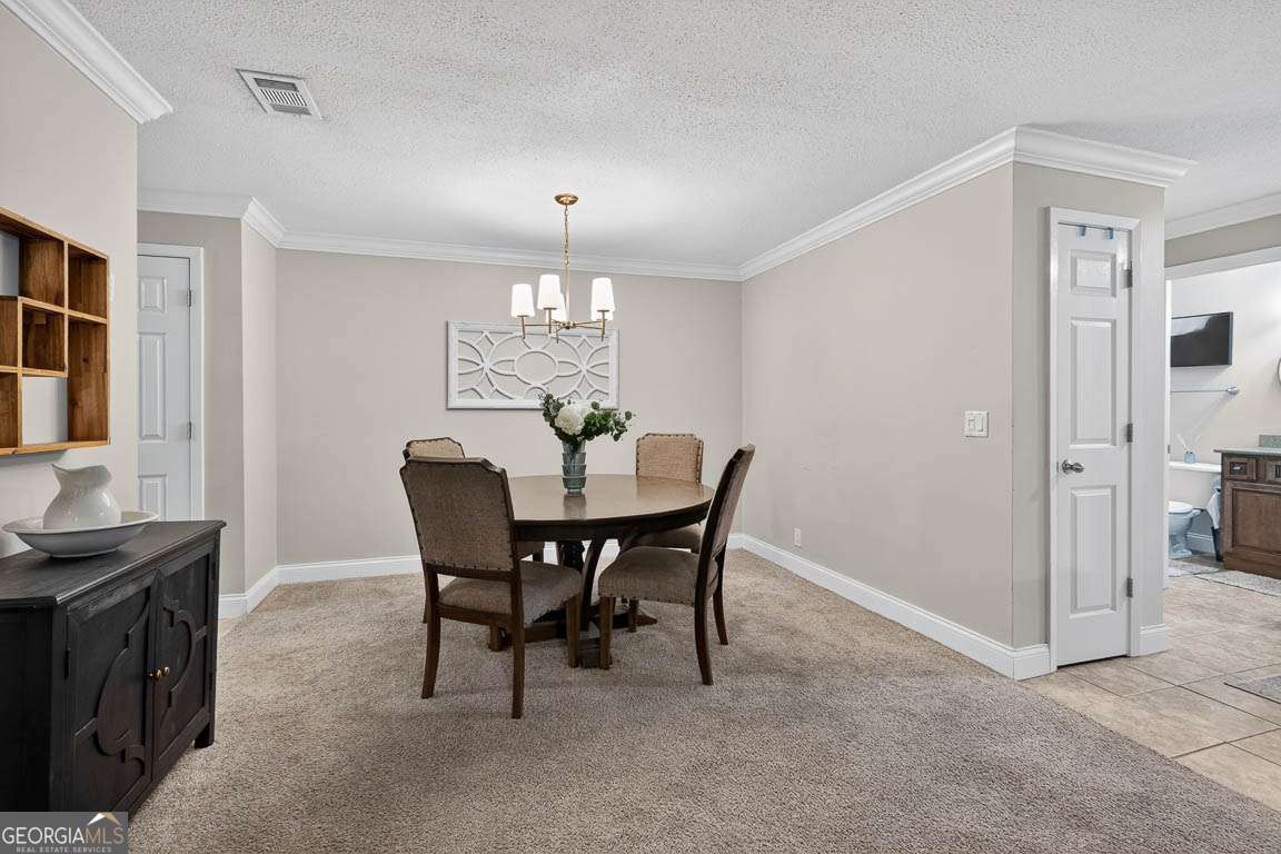 2514 Demere Road, Unit 7 St. Simons, GA 31522 - Photo 8 of 22 a view of a dining room with furniture and chandelier