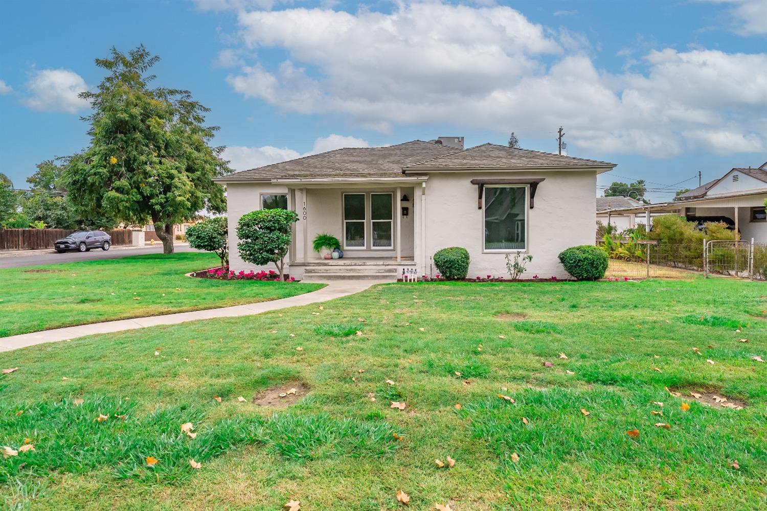 1600 West 5th Street Madera, CA 93637 - Photo 1 of 46 a view of a white house with a yard and sitting area
