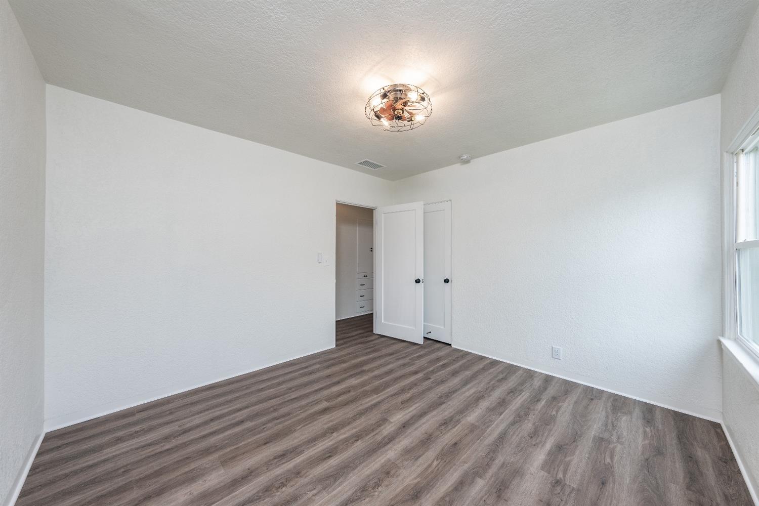 1600 West 5th Street Madera, CA 93637 - Photo 21 of 46 a view of a room with wooden floor and a ceiling fan