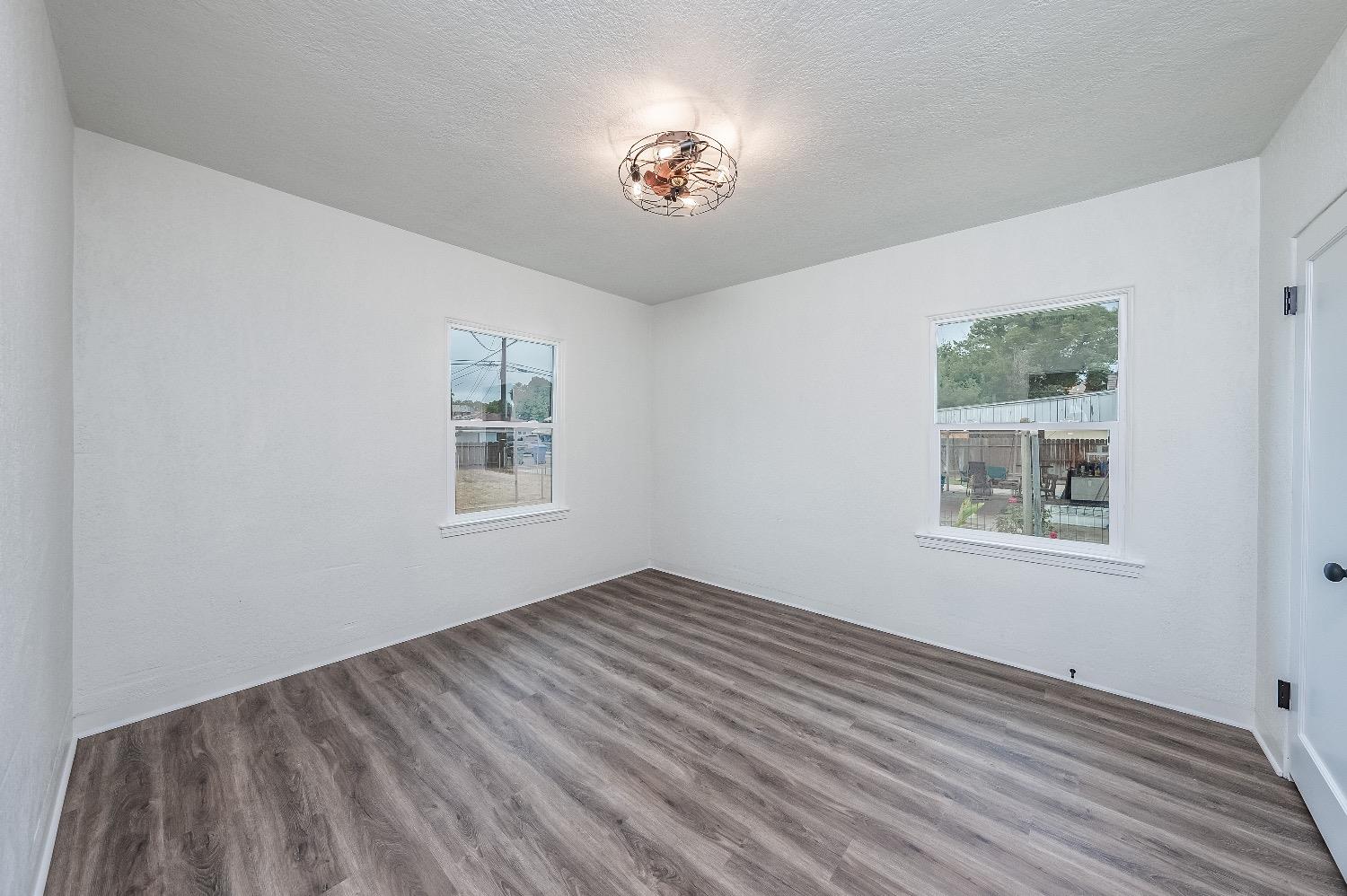 1600 West 5th Street Madera, CA 93637 - Photo 22 of 46 a view of an empty room with window and wooden floor