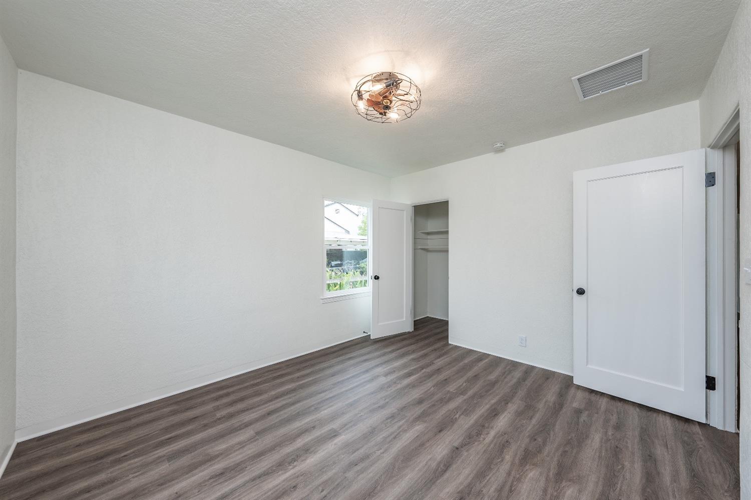 1600 West 5th Street Madera, CA 93637 - Photo 23 of 46 a view of an empty room with a window and wooden floor
