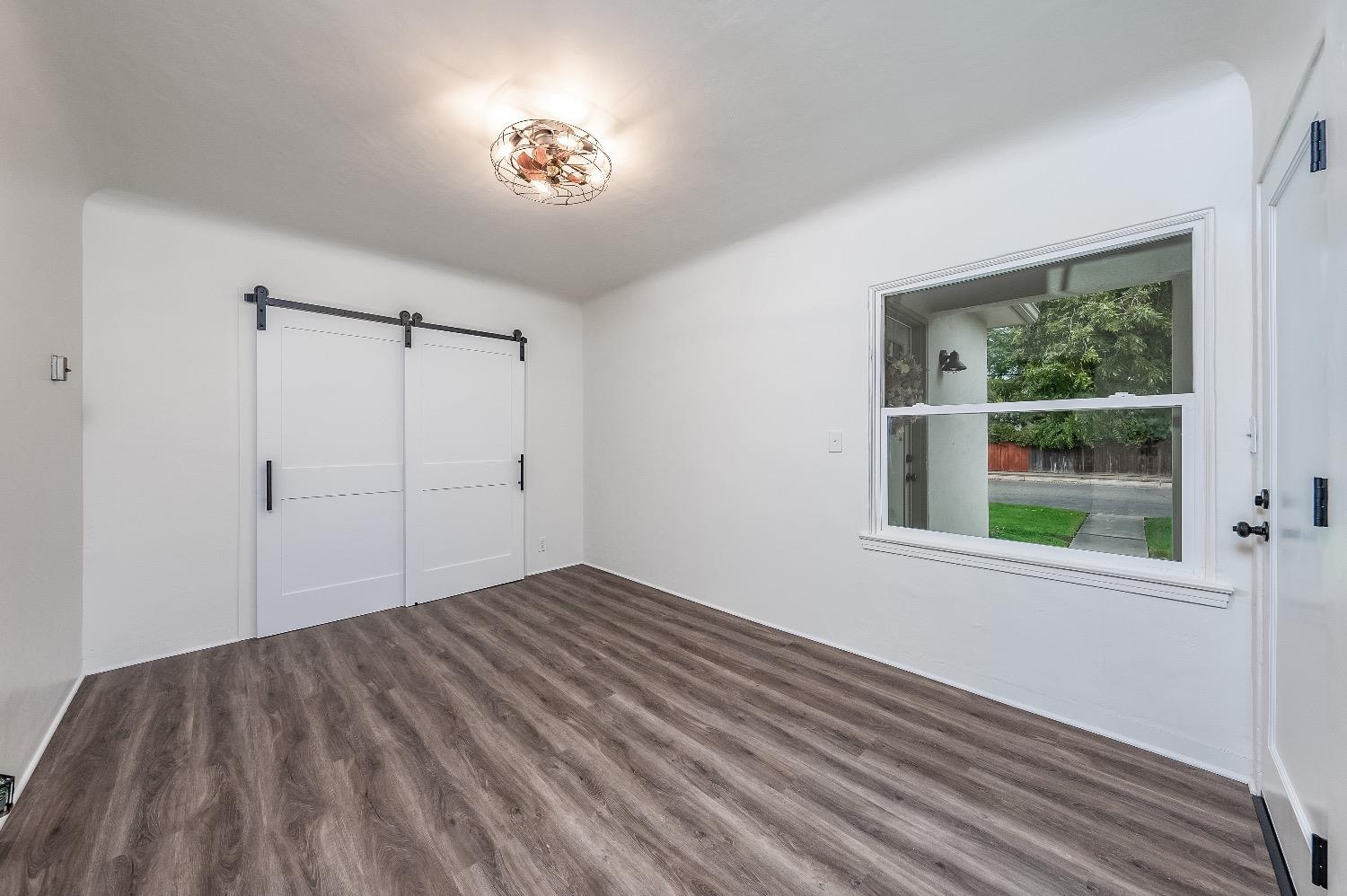 1600 West 5th Street Madera, CA 93637 - Photo 26 of 46 a view of an empty room with wooden floor and a window