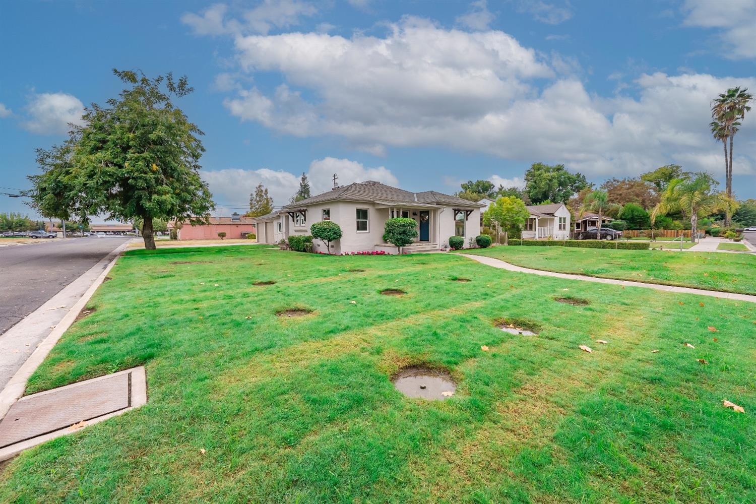 1600 West 5th Street Madera, CA 93637 - Photo 3 of 46 a view of a house with a big yard and large trees
