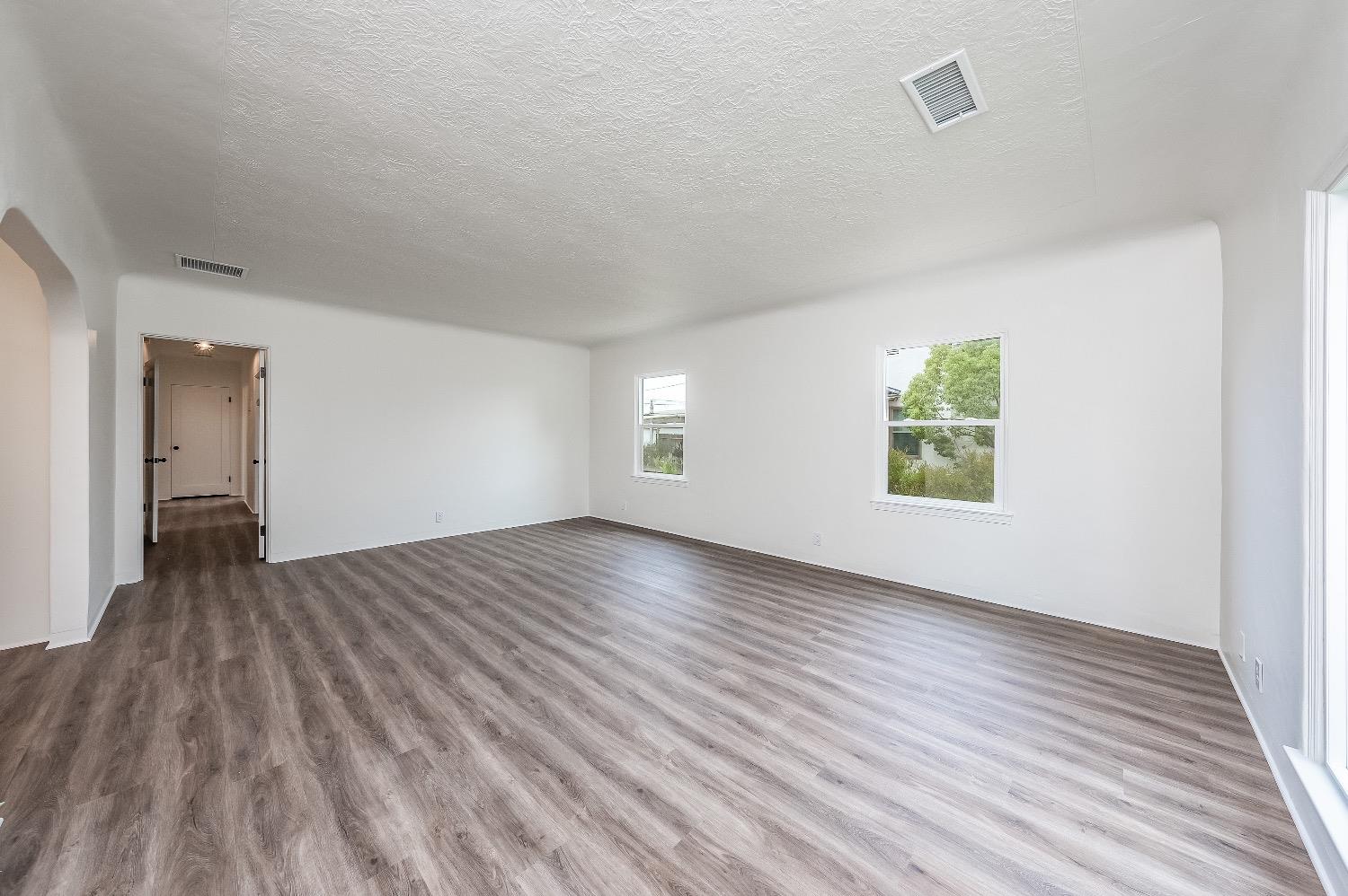 1600 West 5th Street Madera, CA 93637 - Photo 9 of 46 an empty room with wooden floor and windows