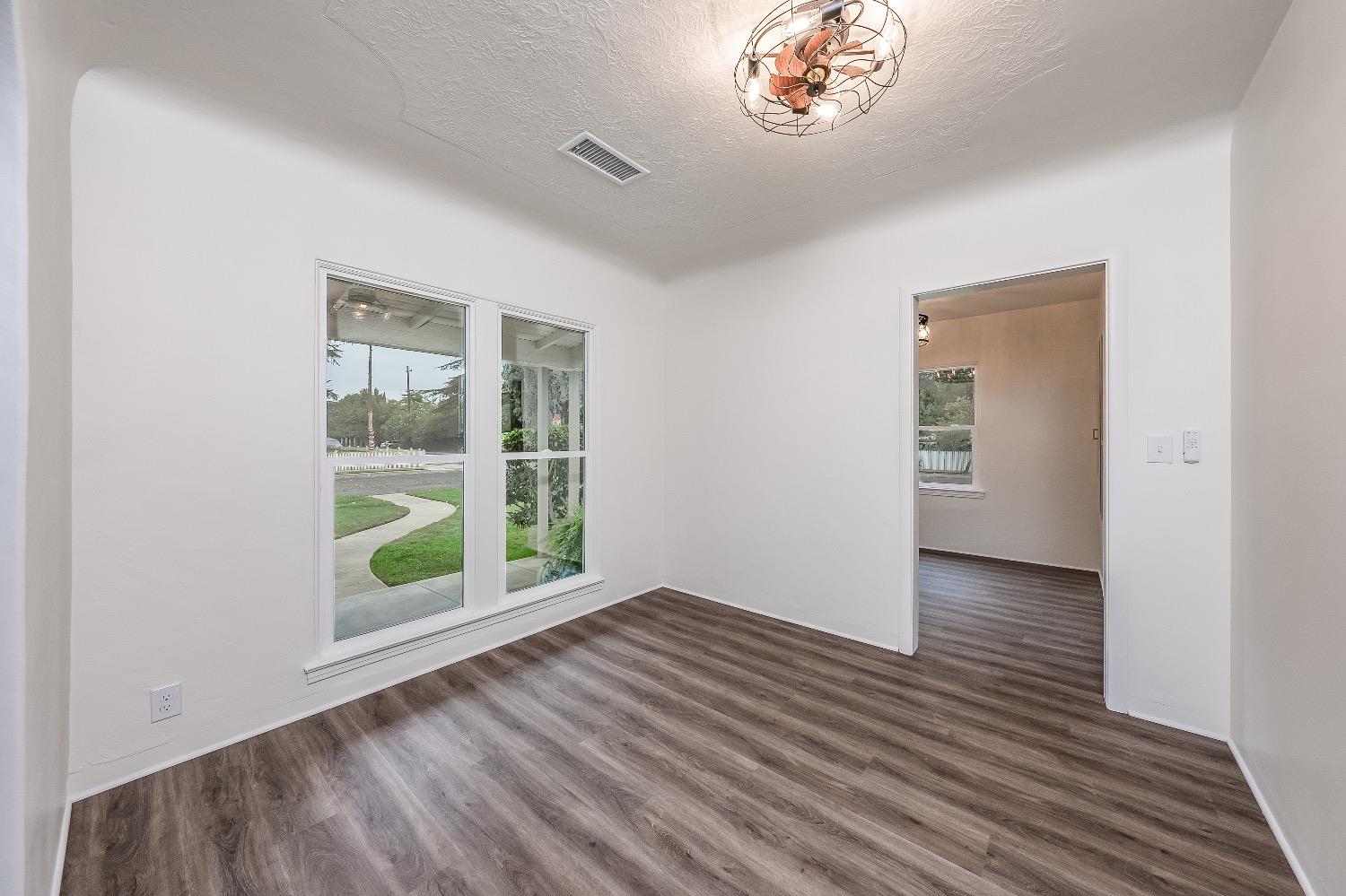 1600 West 5th Street Madera, CA 93637 - Photo 10 of 46 an empty room with wooden floor and a window