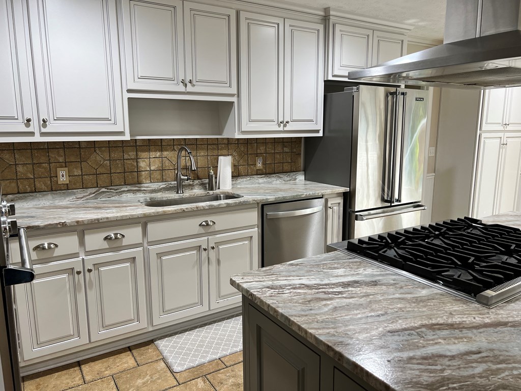 488 Blue Bird Trail Fortson, GA 31808 - Photo 21 of 45 a kitchen with granite countertop a sink stove and refrigerator