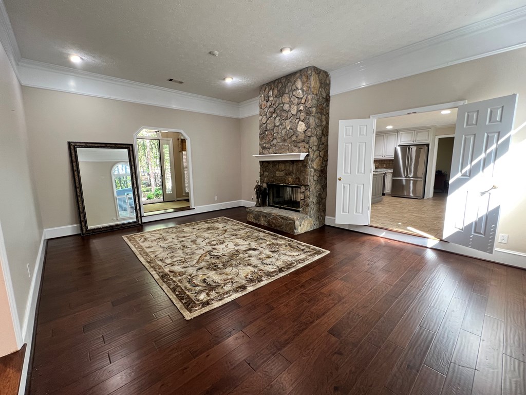 488 Blue Bird Trail Fortson, GA 31808 - Photo 10 of 45 an empty room with wooden floor fireplace and windows
