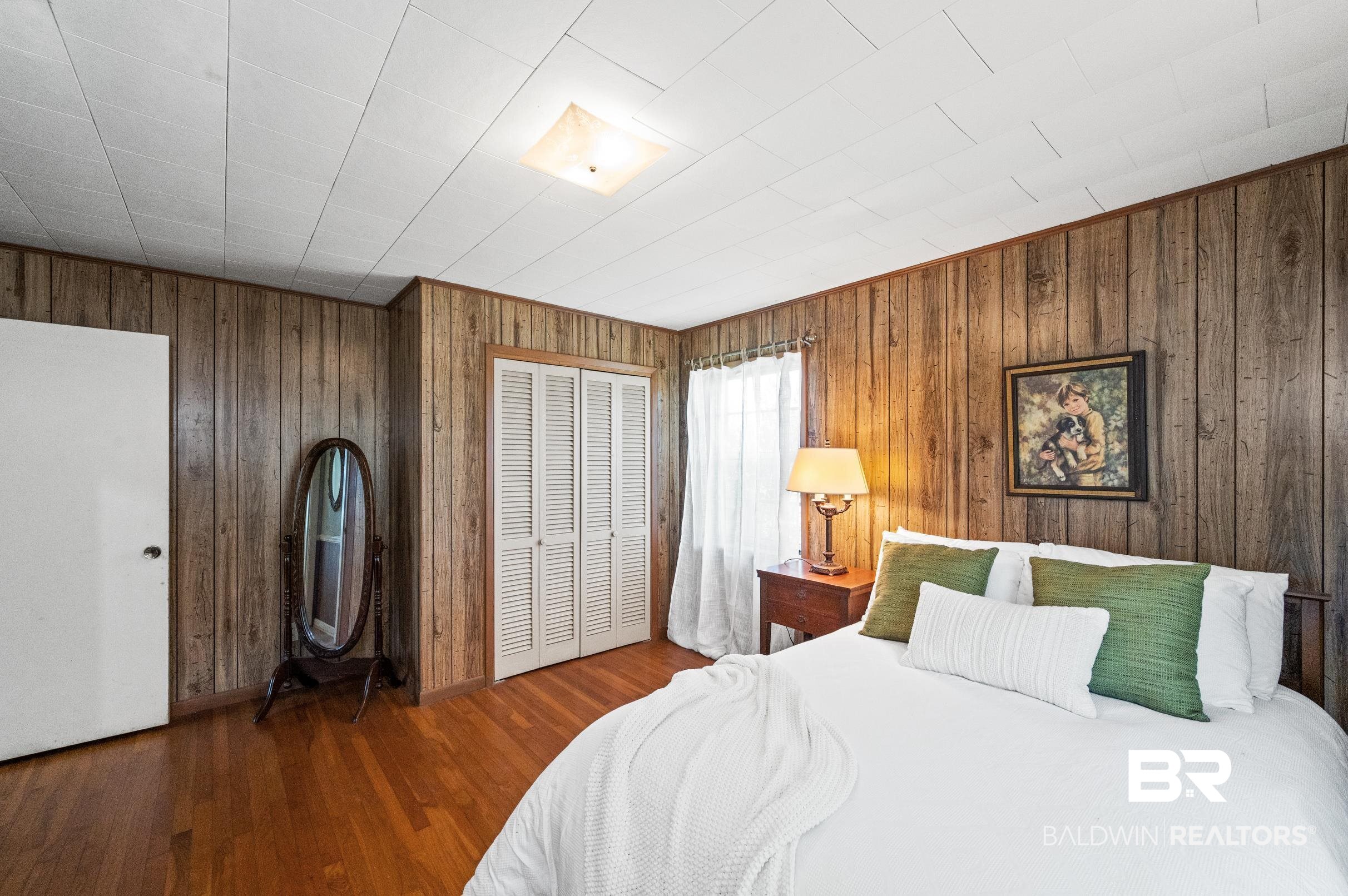 15600 Fackler Road Loxley, AL 36551 - Photo 18 of 51 Bedroom with wooden walls and hardwood / wood-style floors