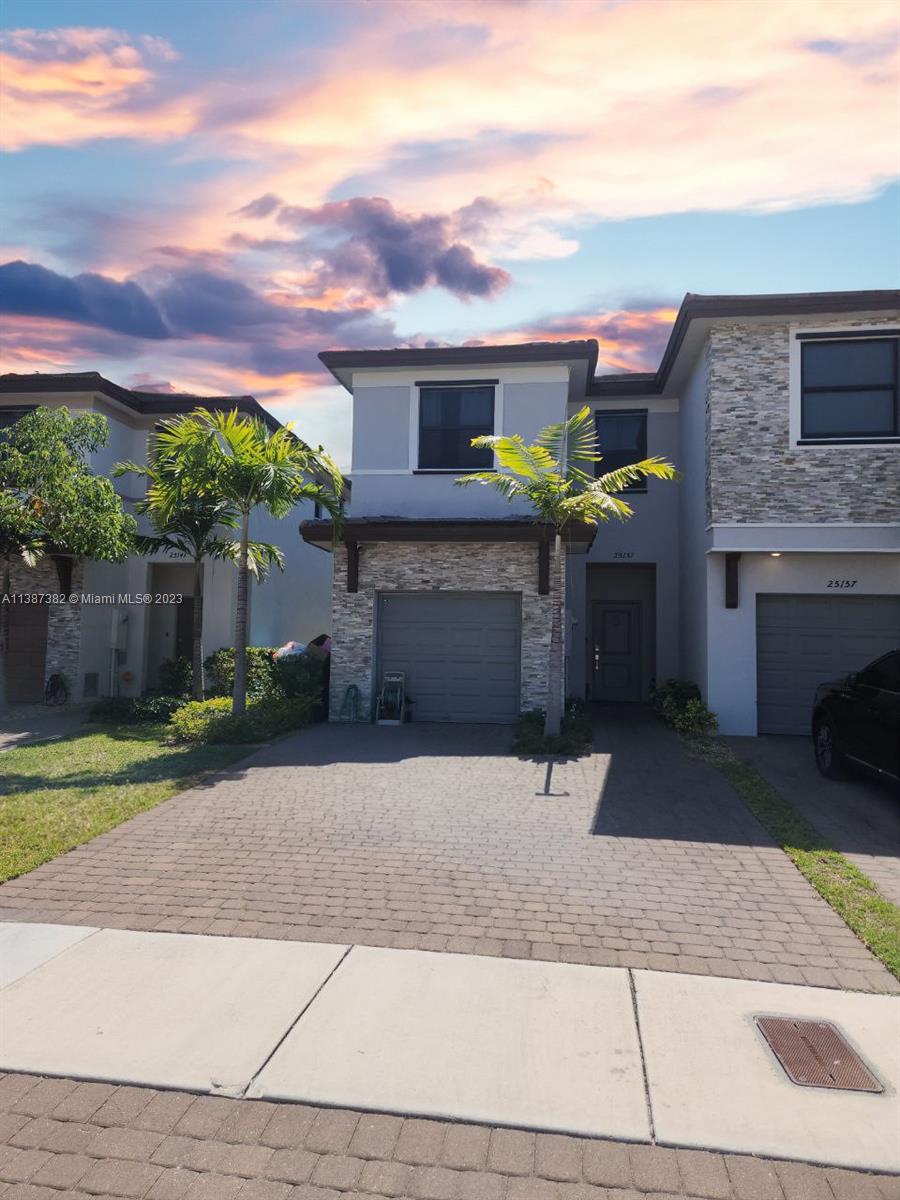 a front view of a house with a yard and a garage
