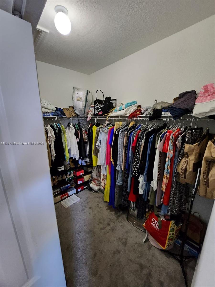 25151 Southwest 108th Court Homestead, FL 33032 - Photo 13 of 15 a view of walk in closet with clothes and shoes