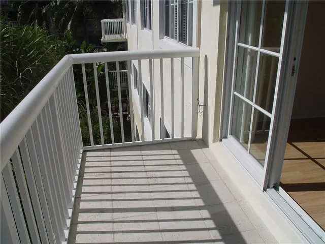a view of a balcony with wooden floor and fence