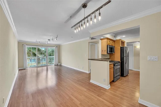 a view of a kitchen with wooden floor and a window