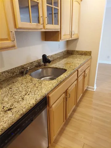 a kitchen with granite countertop sink and cabinets