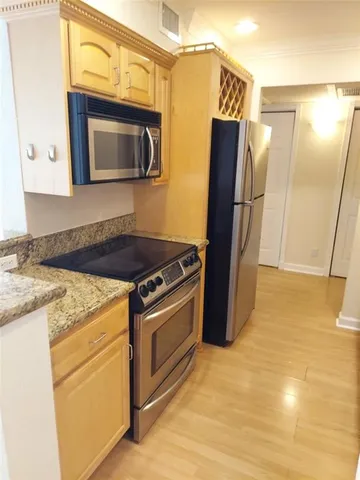 a kitchen with stainless steel appliances granite countertop a refrigerator stove and microwave