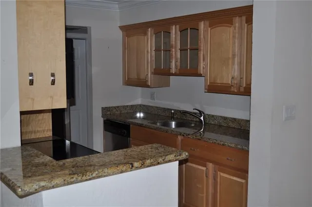 a kitchen with granite countertop a sink and a stove top oven