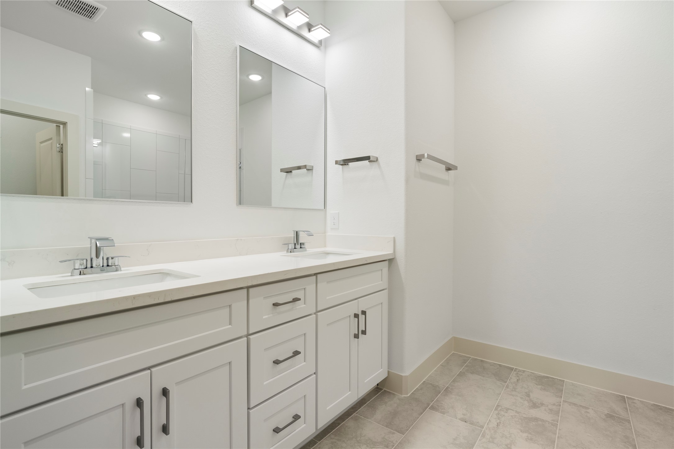 5629 Malmedy Road Houston, TX 77033 - Photo 11 of 24 Modern bathroom featuring a sleek dual-sink vanity with ample storage, complemented by elegant mirrors and contemporary fixtures.
