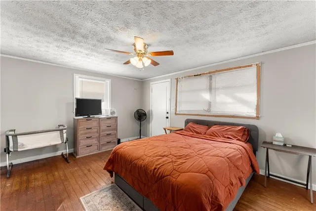 a bedroom with a bed a dresser and flat screen tv