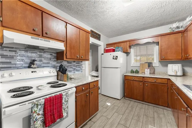 a kitchen with sink cabinets and white appliances