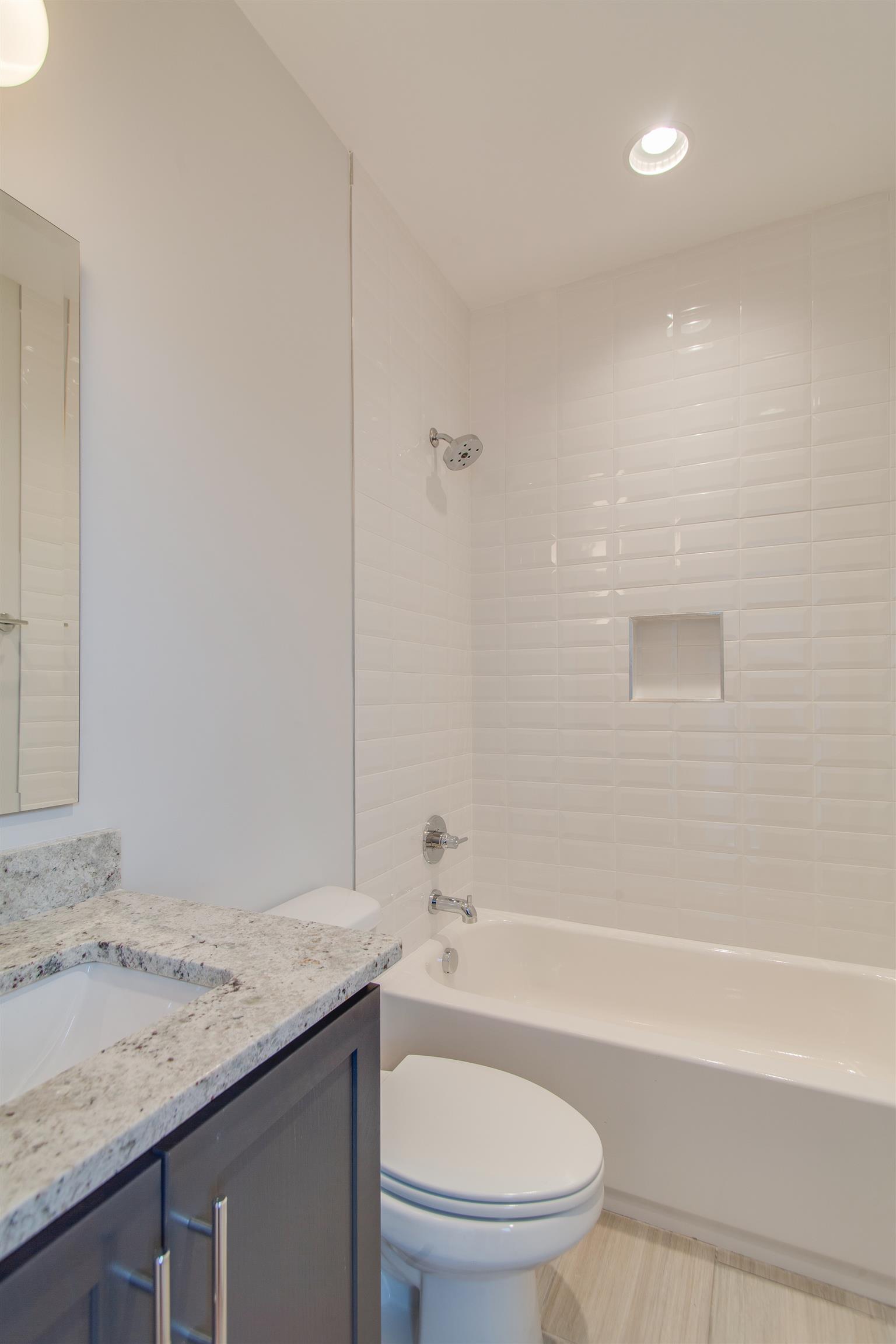 119 A Rains Avenue Nashville, TN 37203 - Photo 16 of 25 a bathroom with a granite countertop sink a toilet and shower