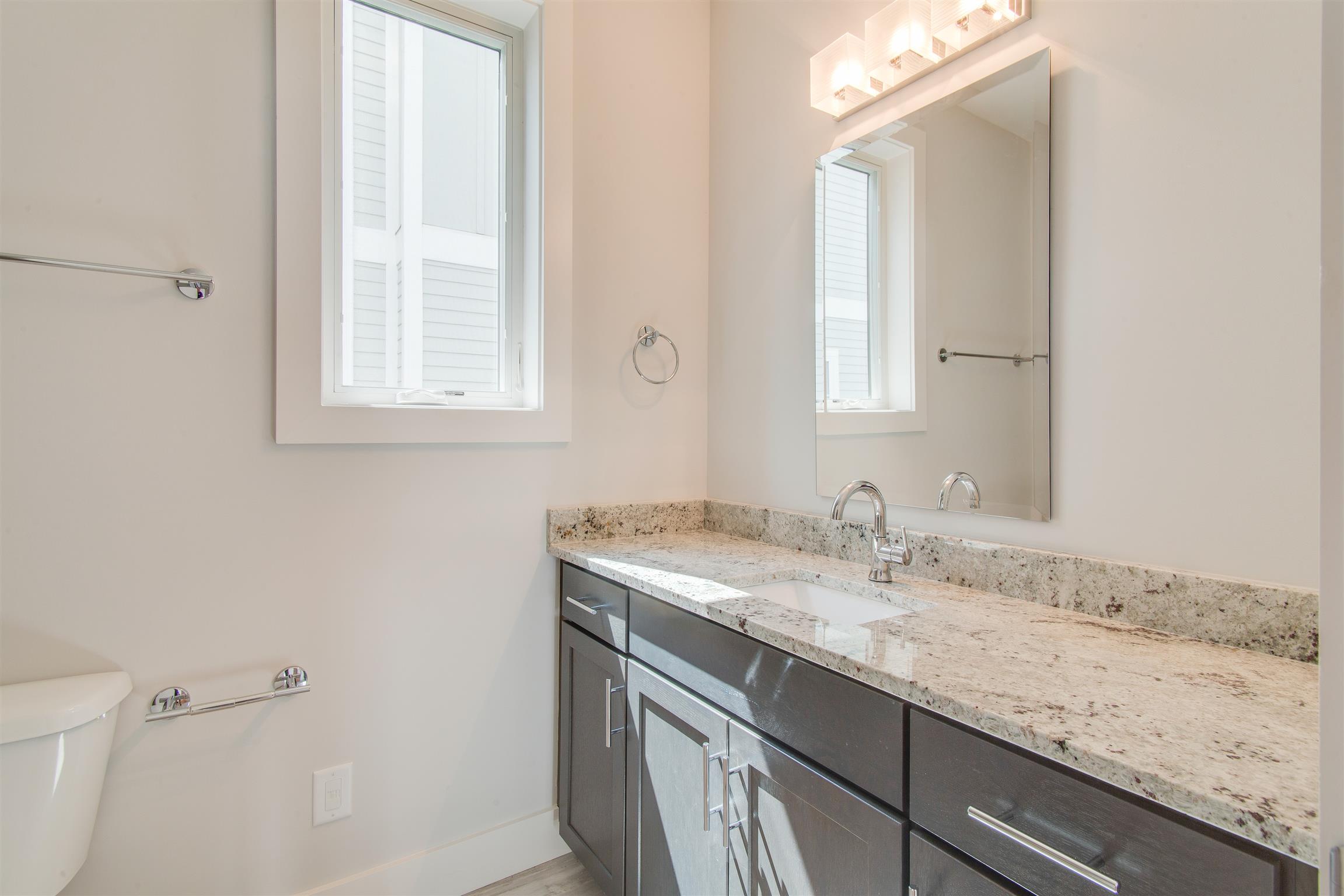 119 A Rains Avenue Nashville, TN 37203 - Photo 5 of 25 a bathroom with a granite countertop sink a toilet and a mirror
