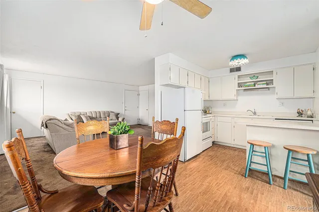 a kitchen with a table chairs a sink dishwasher and cabinets