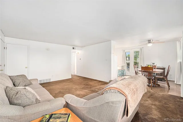 a living room with furniture and a ceiling fan