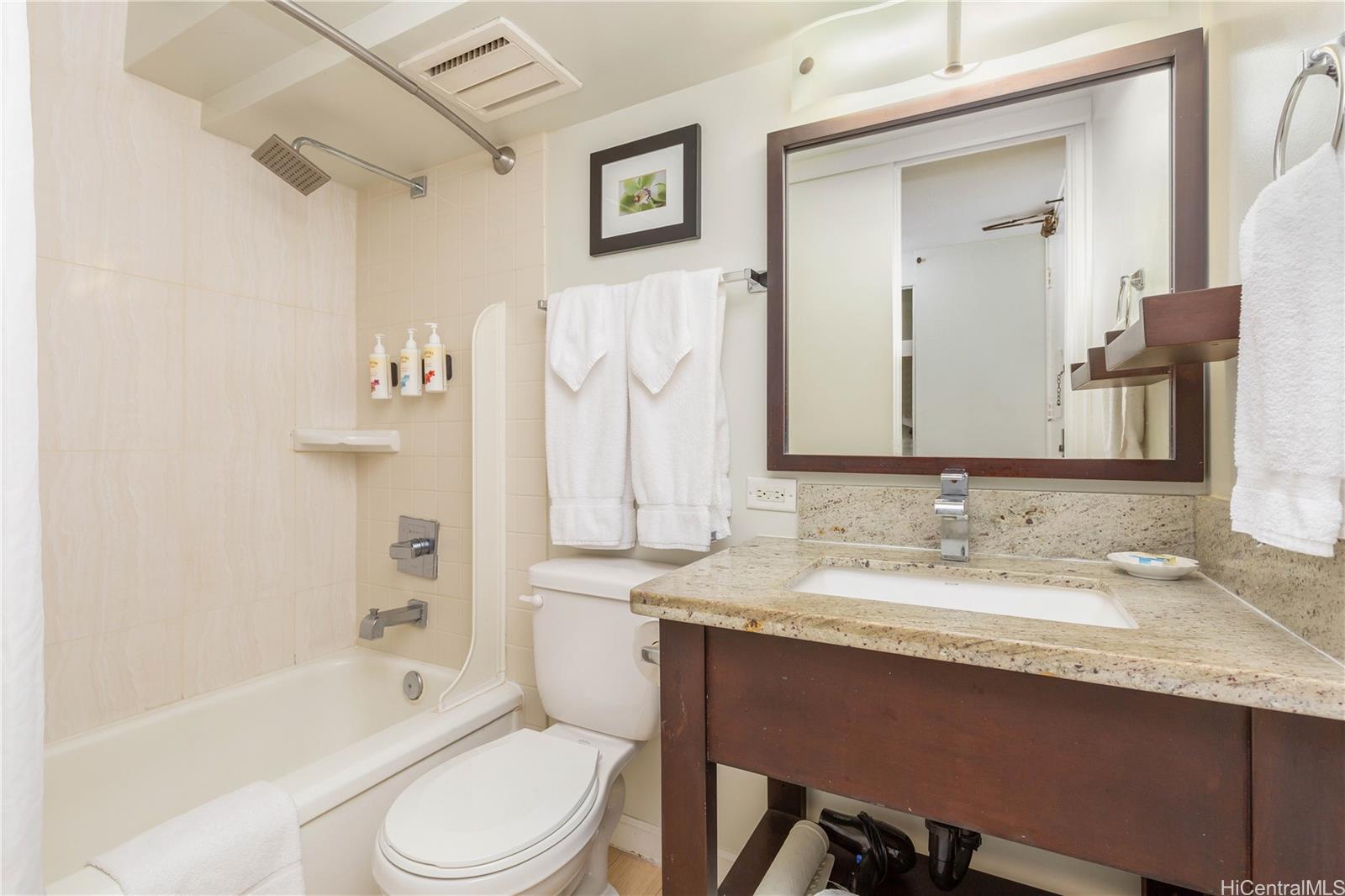 445 Seaside Avenue, Unit 2804 Honolulu, HI 96815 - Photo 15 of 25 a bathroom with a granite countertop sink toilet and shower