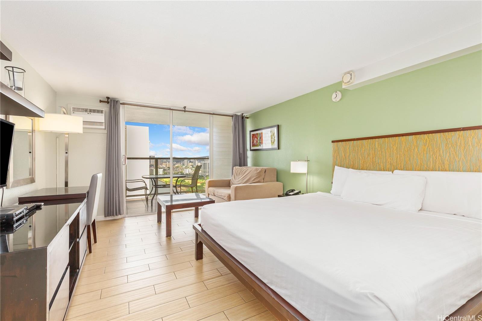 445 Seaside Avenue, Unit 2804 Honolulu, HI 96815 - Photo 3 of 25 a bedroom with a bed a table and chair