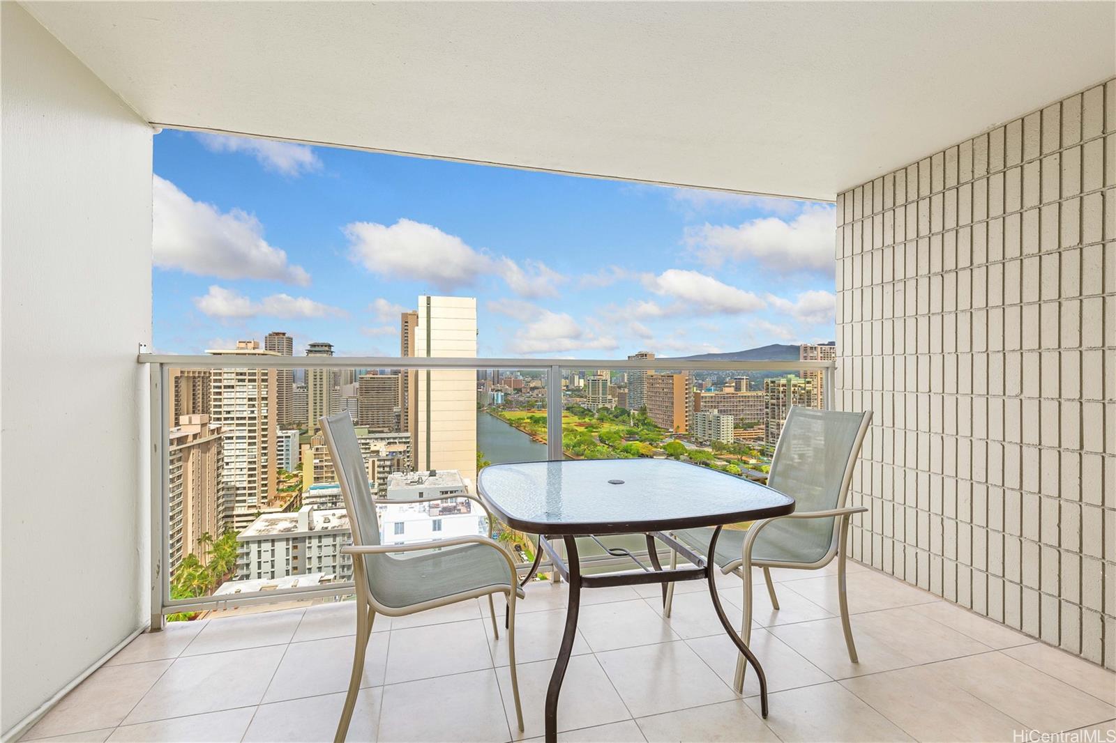 445 Seaside Avenue, Unit 2804 Honolulu, HI 96815 - Photo 8 of 25 a view of a balcony with furniture and a floor to ceiling window