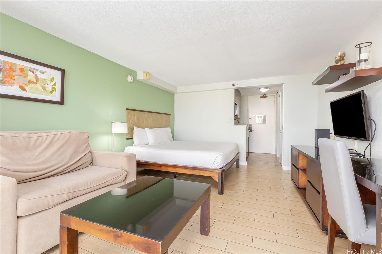 445 Seaside Avenue, Unit 2804 Honolulu, HI 96815 - Photo 9 of 25 a living room with furniture and a flat screen tv