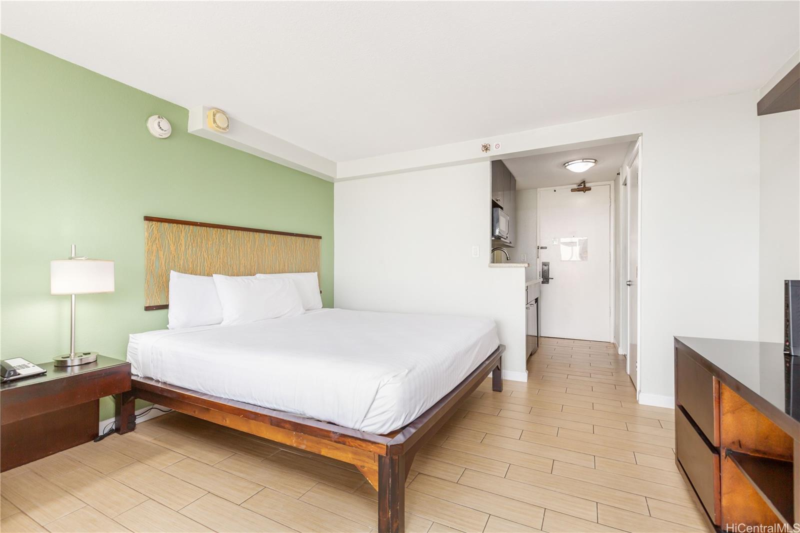 445 Seaside Avenue, Unit 2804 Honolulu, HI 96815 - Photo 10 of 25 a spacious bedroom with a bed and a dresser