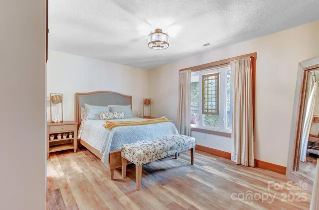 a bedroom with a bed and wooden floor